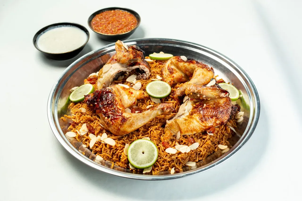Mauritian chicken biryani served on a tray with lime and fresh herbs, the layered briani plate.