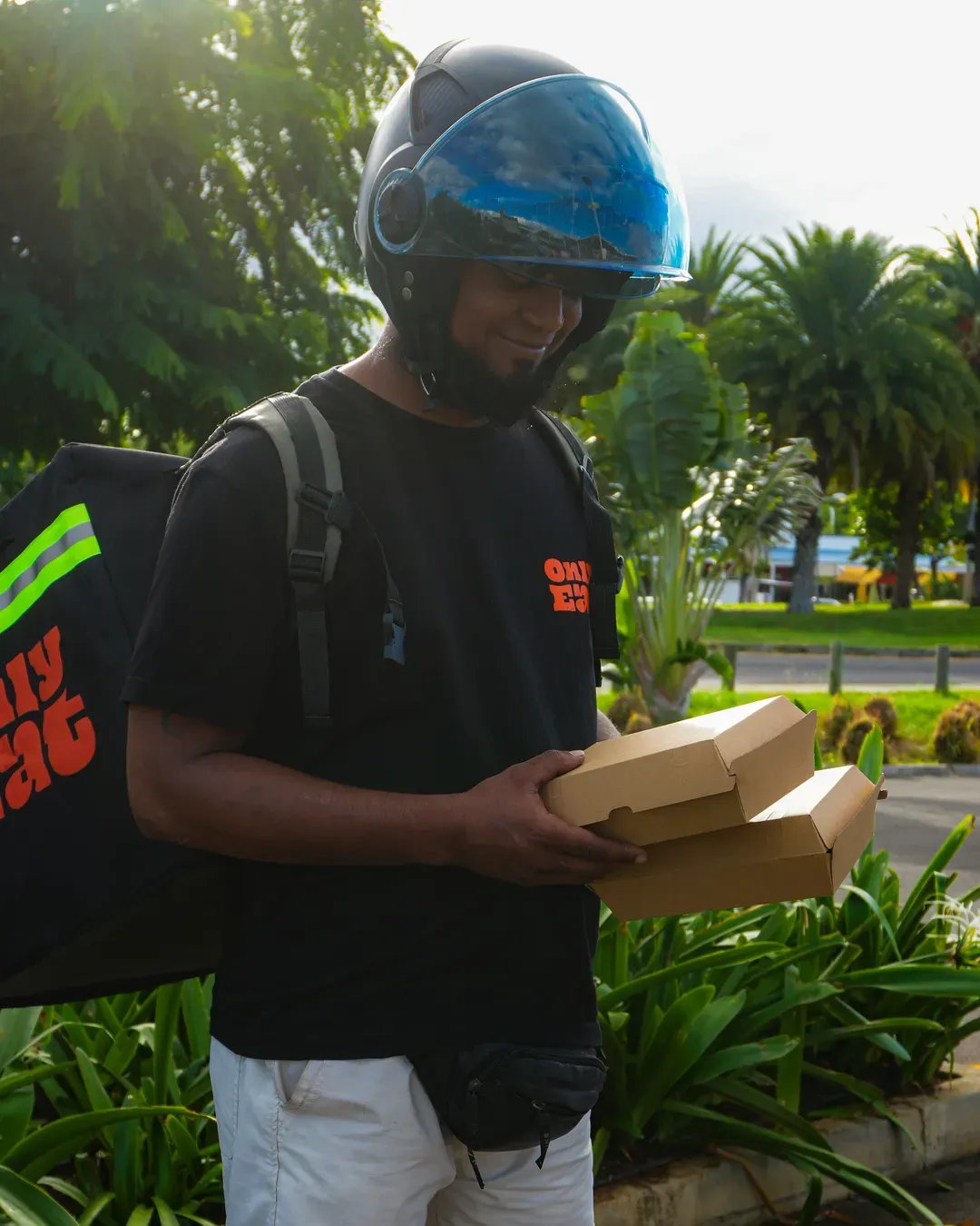 An OnlyEat rider with a delivery backpack brings a hot order. Food delivery in Mauritius, for real.
