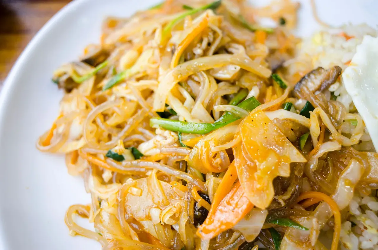 Mine frit, Mauritian fried egg noodles with cabbage, carrot and vegetables on a plate.